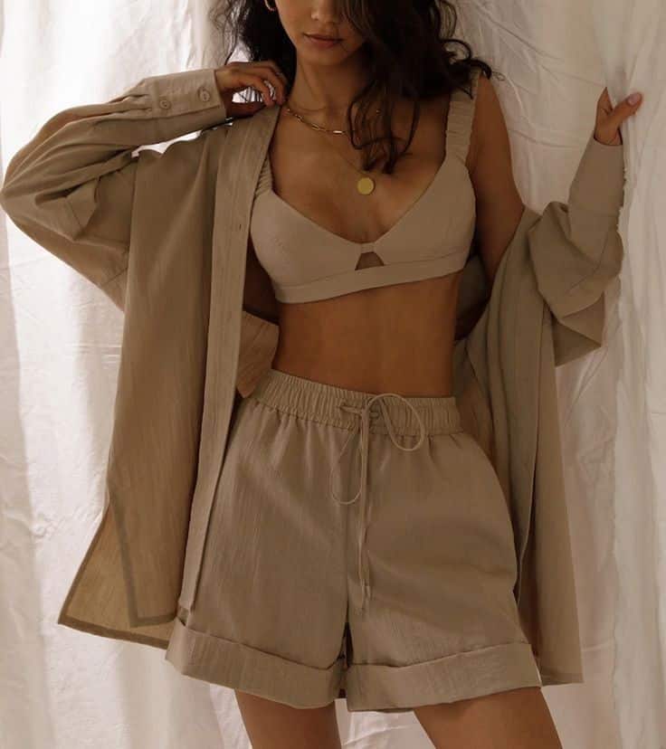 _ 21 Woman in a beige loungewear set with a relaxed, stylish vibe, featuring shorts, a bralette, and an oversized shirt. | Sky Rye Design Woman in a beige loungewear set with a relaxed, stylish vibe, featuring shorts, a bralette, and an oversized shirt.
