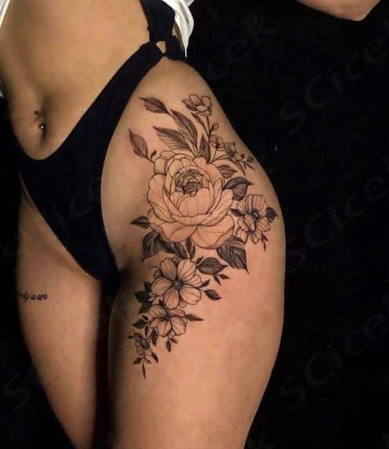 _ 22 Floral thigh tattoo featuring a large rose and smaller flowers, showcasing detailed linework on a woman's upper leg. | Sky Rye Design Floral thigh tattoo featuring a large rose and smaller flowers, showcasing detailed linework on a woman's upper leg.