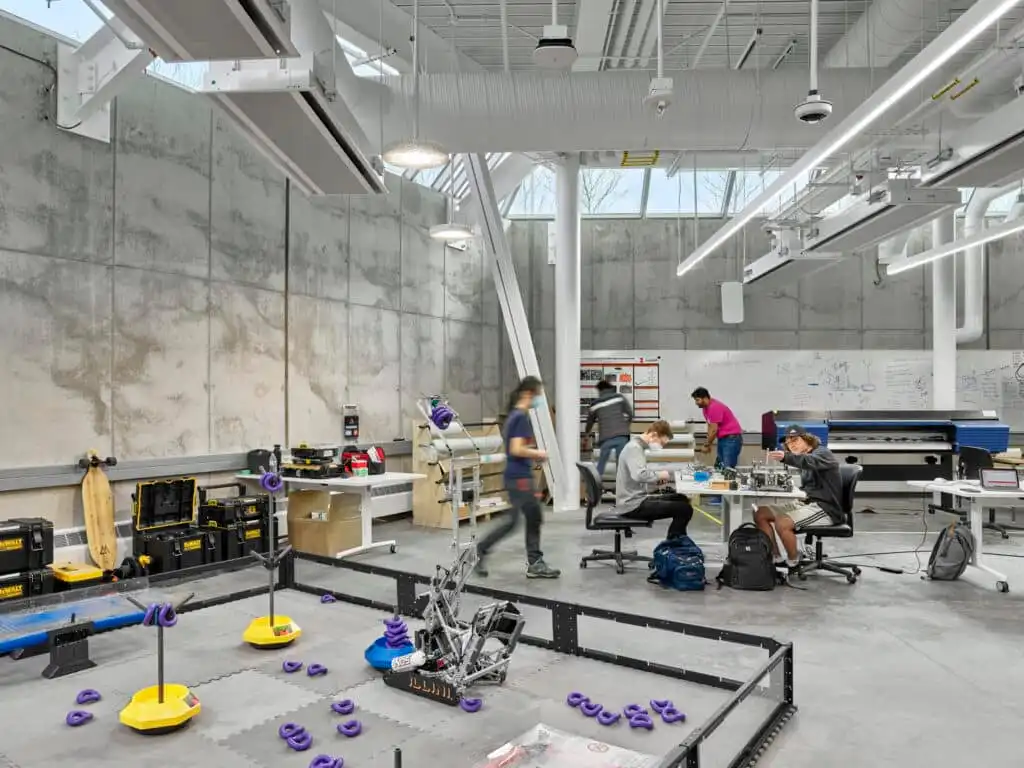 Students collaborating in a modern robotics lab, surrounded by tools and equipment, working on various engineering projects.