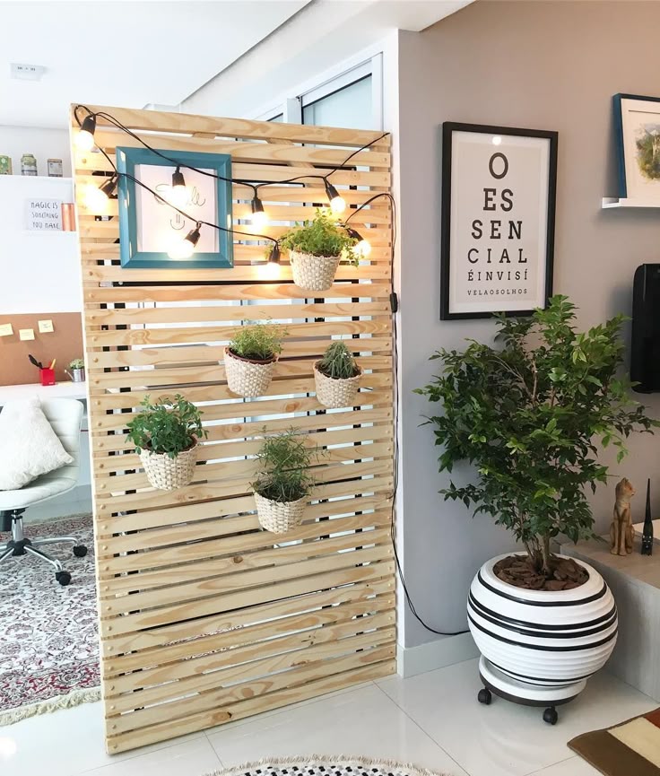 _ 24 Indoor decor featuring a wooden divider with hanging plants, string lights, and framed art. Enhances a modern home office space. | Sky Rye Design Indoor decor featuring a wooden divider with hanging plants, string lights, and framed art. Enhances a modern home office space.