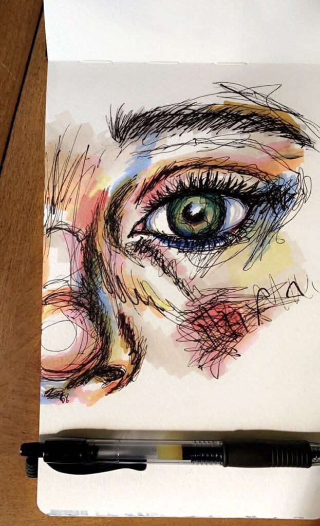Colorful sketch of a realistic eye and nose on paper with a black pen laying across. Artistic drawing with vibrant details.