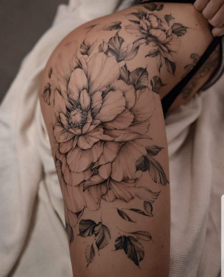 _ 27 Floral tattoo design on thigh featuring intricate black and white petals and leaves, showcasing detailed artistry and elegant placement. | Sky Rye Design Floral tattoo design on thigh featuring intricate black and white petals and leaves, showcasing detailed artistry and elegant placement.