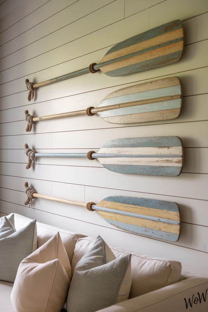 27 Coastal Bedroom Decor Ideas That Feel Like a Seaside Escape Decorative wooden paddles with blue and beige stripes enhance a nautical-themed room with shiplap walls and cozy cushions. | Sky Rye Design Decorative wooden paddles with blue and beige stripes enhance a nautical-themed room with shiplap walls and cozy cushions.