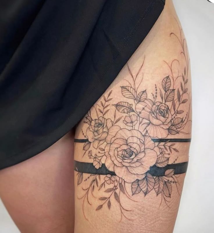 _ 29 Elegant floral tattoo design on the upper thigh, featuring roses and leaves with bold black lines for a stylish and intricate look. | Sky Rye Design Elegant floral tattoo design on the upper thigh, featuring roses and leaves with bold black lines for a stylish and intricate look.