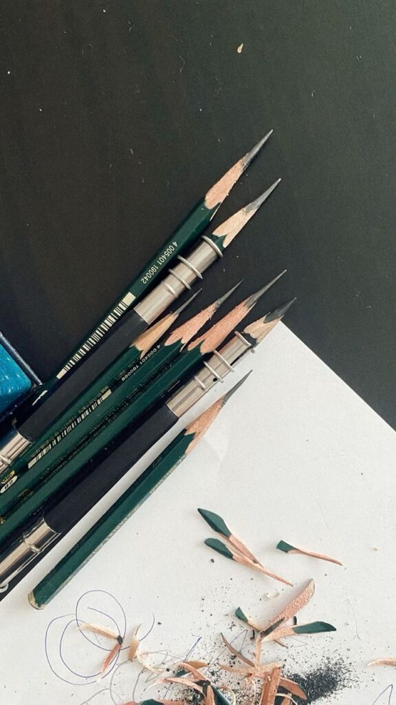 _ 3 Sharpened green pencils on a black and white background with pencil shavings scattered nearby. Perfect for art or writing themed content. | Sky Rye Design Sharpened green pencils on a black and white background with pencil shavings scattered nearby. Perfect for art or writing themed content.
