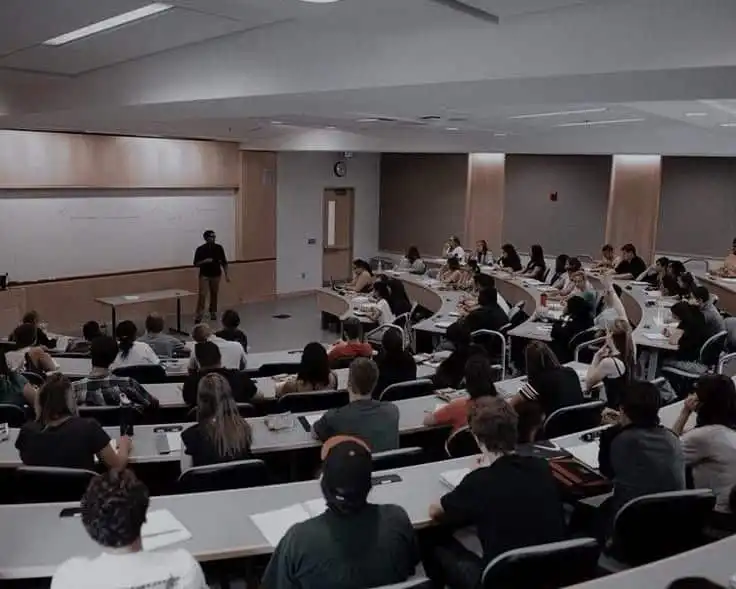 Lecture hall filled with attentive students listening to a lecturer, enhancing their academic knowledge and classroom experience.