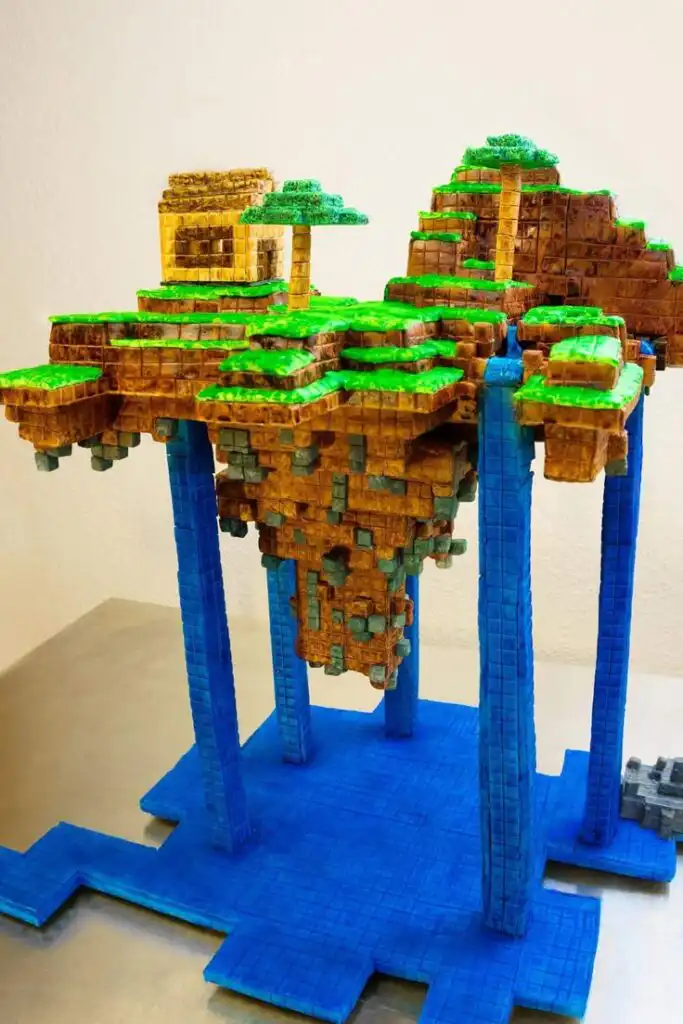 _ 3 Colorful voxel art structure resembling a floating island with trees and waterfall, supported by blue pillars on a platform. | Sky Rye Design Colorful voxel art structure resembling a floating island with trees and waterfall, supported by blue pillars on a platform.