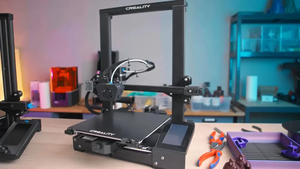 Creality 3D printer on a workbench with tools and 3D printed objects, showcasing desktop 3D printing setup in a modern studio.