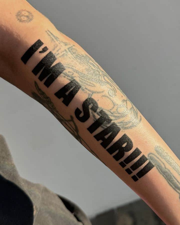 Tattooed arm with large text saying I'M A STAR!!! in bold, showcasing personal empowerment and unique ink art. tattoo font styles