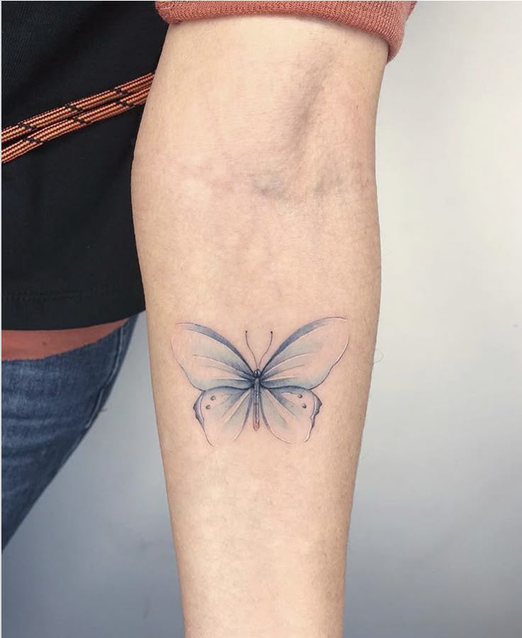 _ 34 Forearm with delicate butterfly tattoo in black and gray, showcasing minimalist design and elegant details on light skin. | Sky Rye Design Forearm with delicate butterfly tattoo in black and gray, showcasing minimalist design and elegant details on light skin.