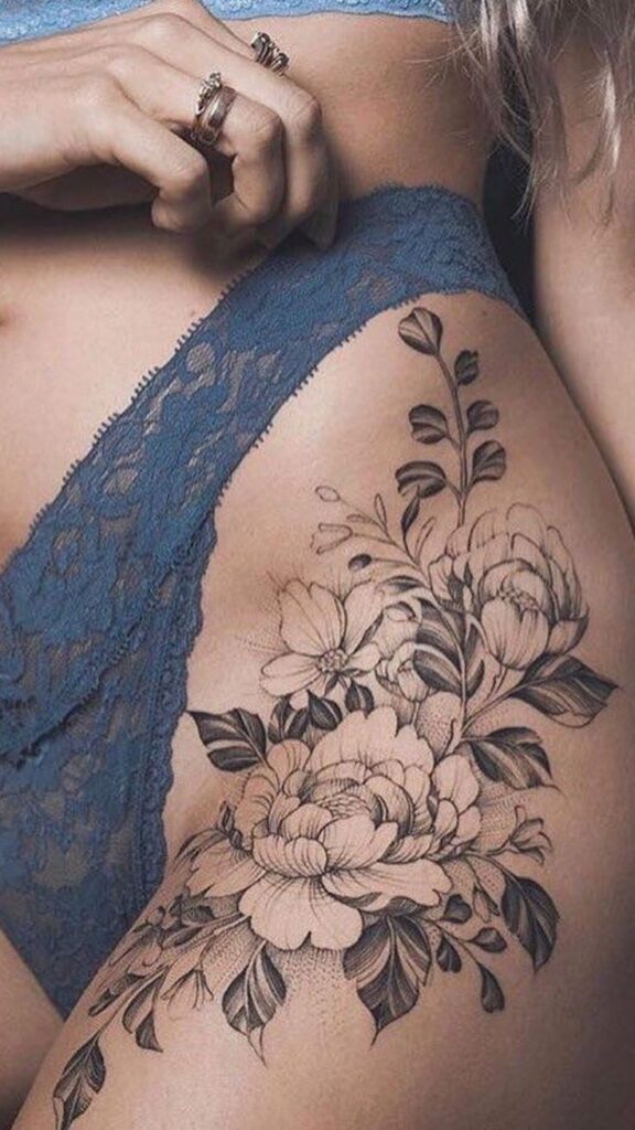 _ 35 Floral thigh tattoo in black ink on a woman, complemented by blue lace lingerie, showcasing intricate flower details and leaves. | Sky Rye Design Floral thigh tattoo in black ink on a woman, complemented by blue lace lingerie, showcasing intricate flower details and leaves.
