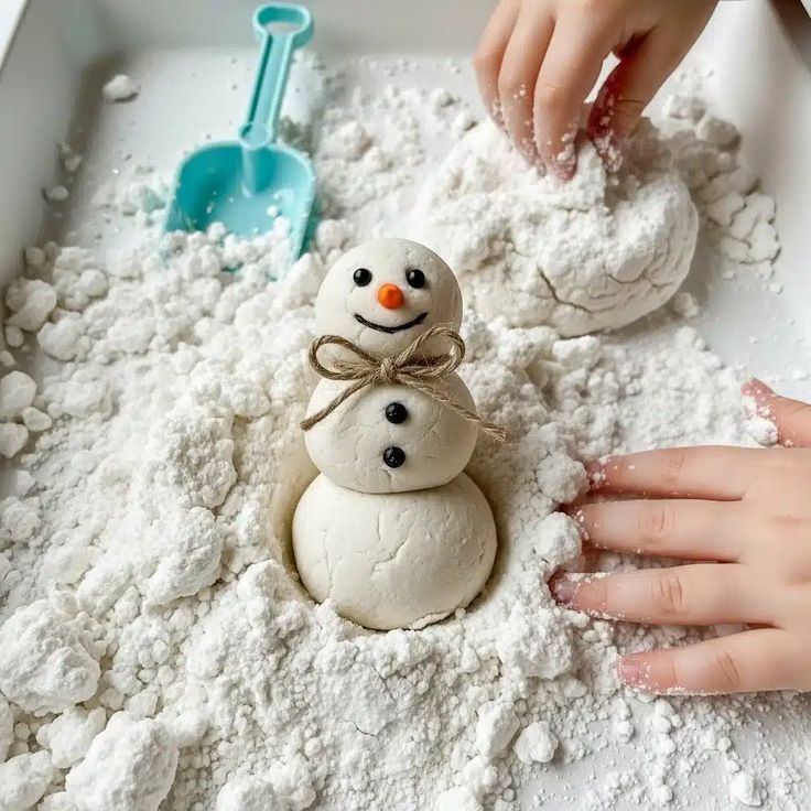 372b5bd887c725ecd3c35c3a274fcfee Child making a small playdough snowman with a shovel and hands in a bin of flour. Fun winter indoor activity for kids. | Sky Rye Design Child making a small playdough snowman with a shovel and hands in a bin of flour. Fun winter indoor activity for kids.