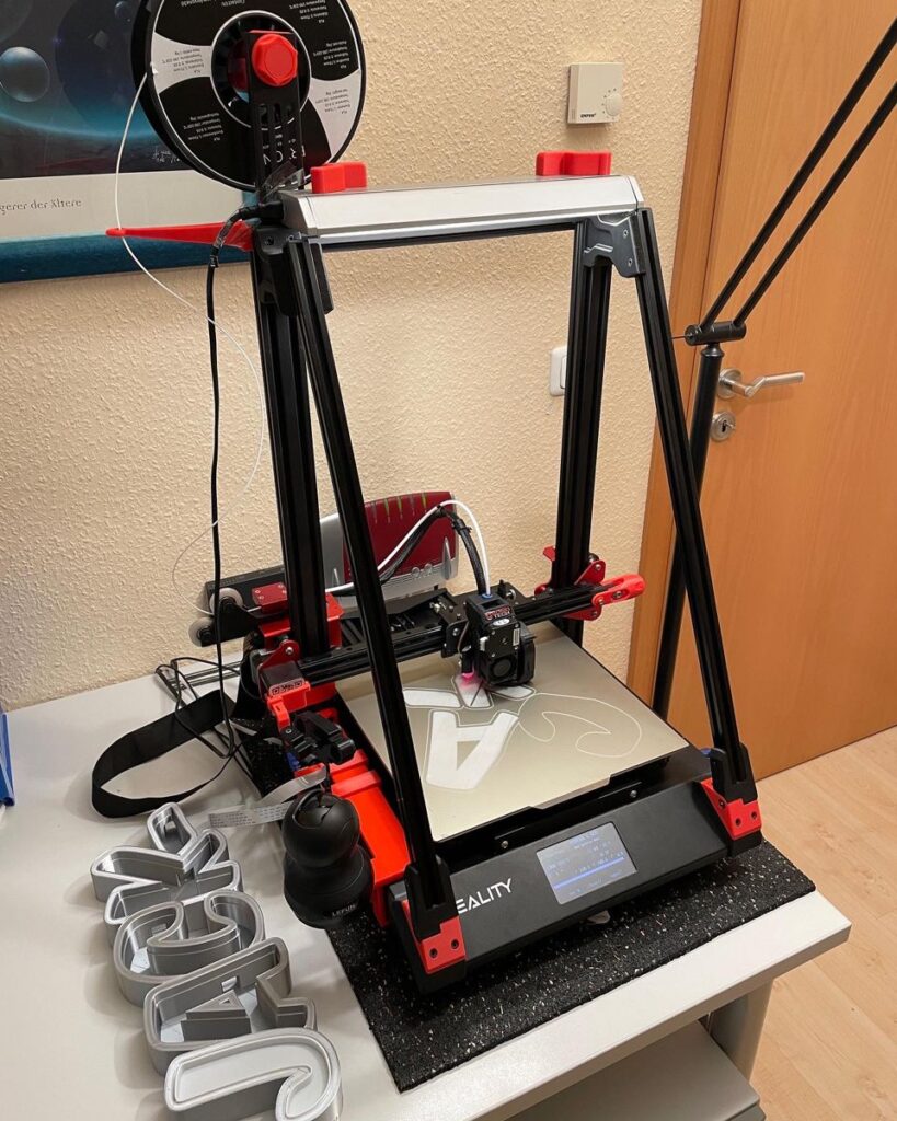 3d9766964e5e19befb6a9e50709cf7f4 3D printer creating letter cutouts on a desk, showcasing modern design and technology. | Sky Rye Design 3D printer creating letter cutouts on a desk, showcasing modern design and technology.