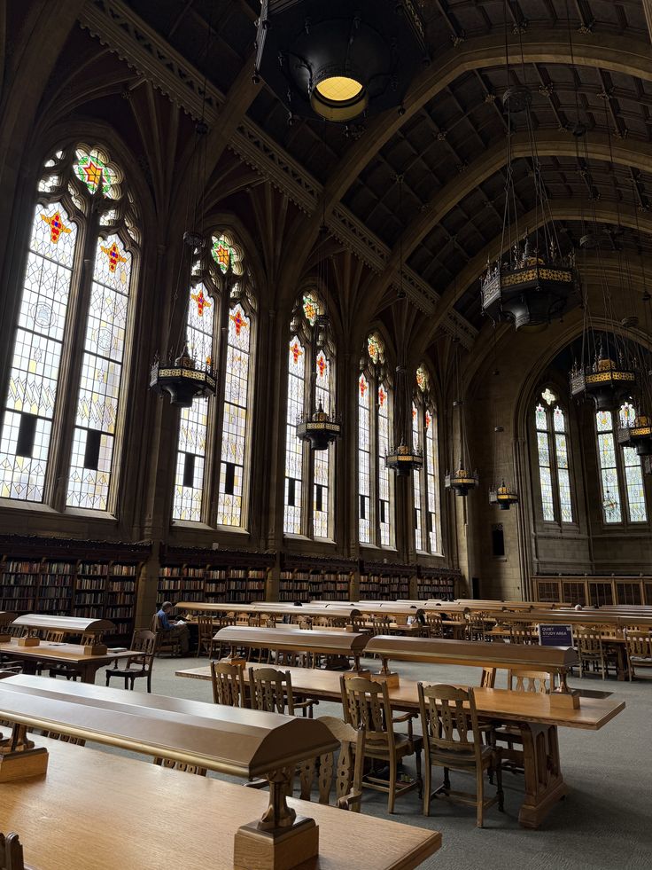 3ea67b57-7ef6-4516-a283-aebae13c1fe6 Historic library interior with arched windows, stained glass, wooden tables, and bookshelves, offering a quiet study environment. | Sky Rye Design Historic library interior with arched windows, stained glass, wooden tables, and bookshelves, offering a quiet study environment.