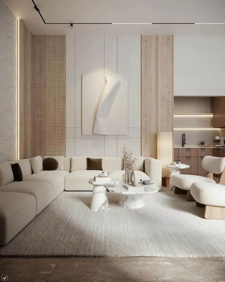 Modern living room with minimalist beige sofas, abstract wall art, and marble tables, creating a cozy and elegant atmosphere.