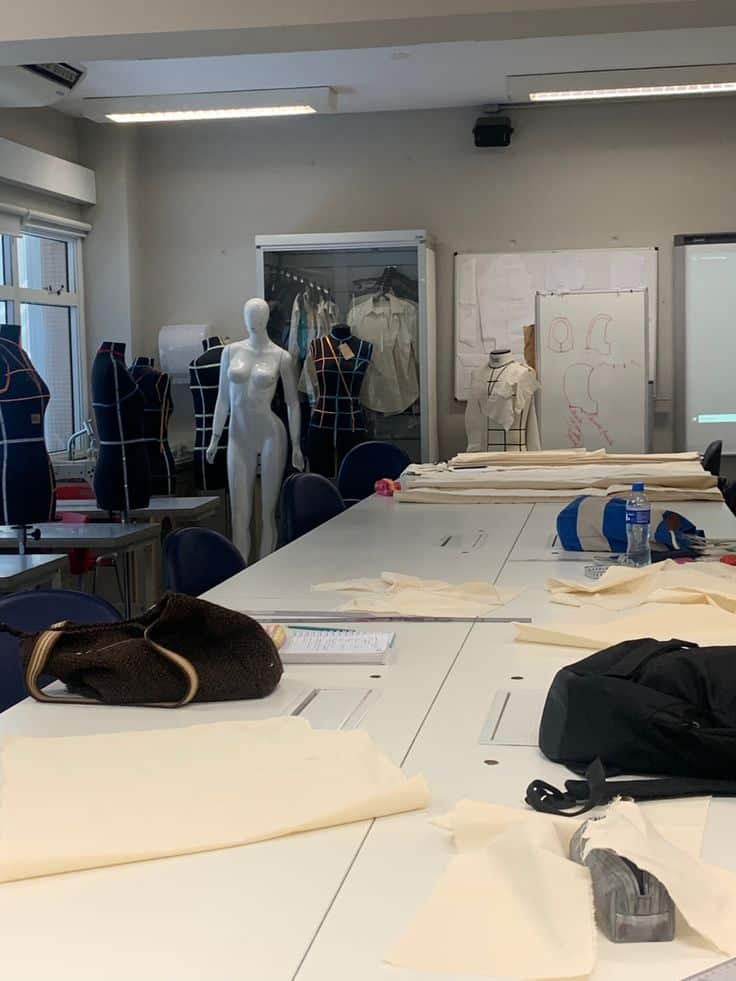 _ 4 Fashion design studio with mannequins, fabric, and tools on a large table, showcasing a creative workspace for garment creation. | Sky Rye Design Fashion design studio with mannequins, fabric, and tools on a large table, showcasing a creative workspace for garment creation.