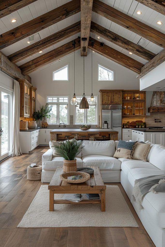 40 Barnhouse Decor Ideas_ Designs for Modern Country Living Rustic modern living room with exposed wood beams, cozy white sectional, and natural accents. Open-plan design with lots of natural light. | Sky Rye Design Rustic modern living room with exposed wood beams, cozy white sectional, and natural accents. Open-plan design with lots of natural light.