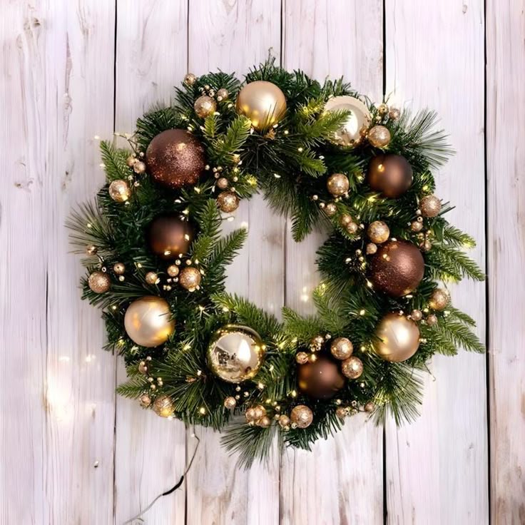 4078e8e40a3d74feb03bcf796b61457e Festive Christmas wreath with gold and brown ornaments, lights on pine branches, hanging on a white wooden wall. Perfect holiday decor. | Sky Rye Design Festive Christmas wreath with gold and brown ornaments, lights on pine branches, hanging on a white wooden wall. Perfect holiday decor.