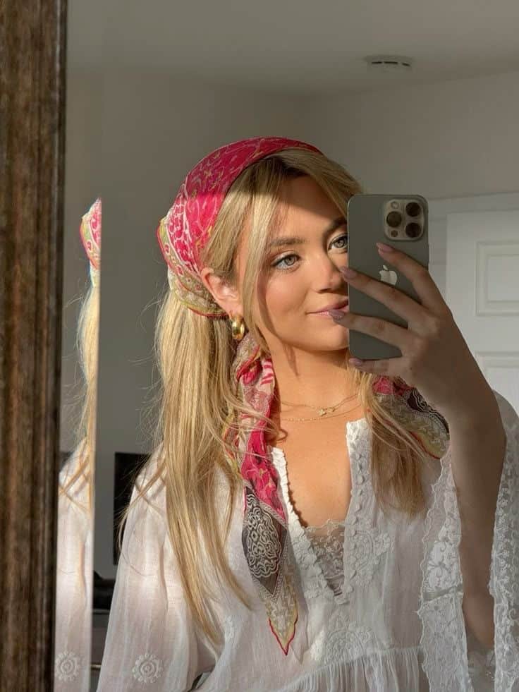 _ 44 Woman taking a mirror selfie, wearing a white lace blouse and a colorful headscarf, in a warmly lit room. | Sky Rye Design Woman taking a mirror selfie, wearing a white lace blouse and a colorful headscarf, in a warmly lit room.