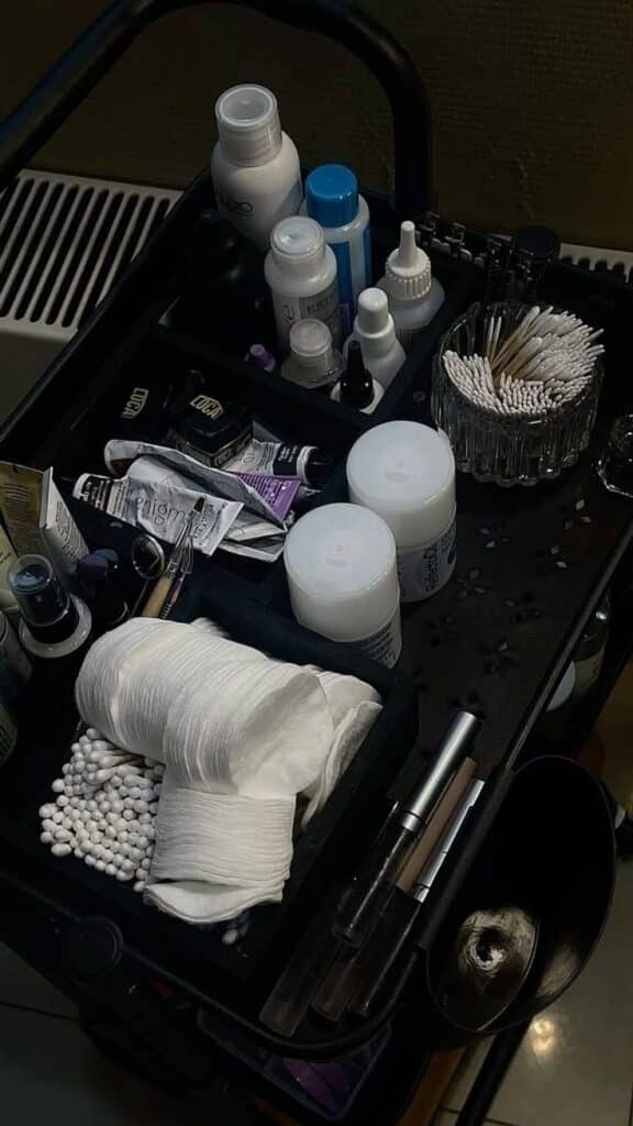 _ 5 Beauty salon workstation with skincare bottles, cotton pads, and tools organized on a black trolley, ideal for professional treatments. | Sky Rye Design Beauty salon workstation with skincare bottles, cotton pads, and tools organized on a black trolley, ideal for professional treatments.