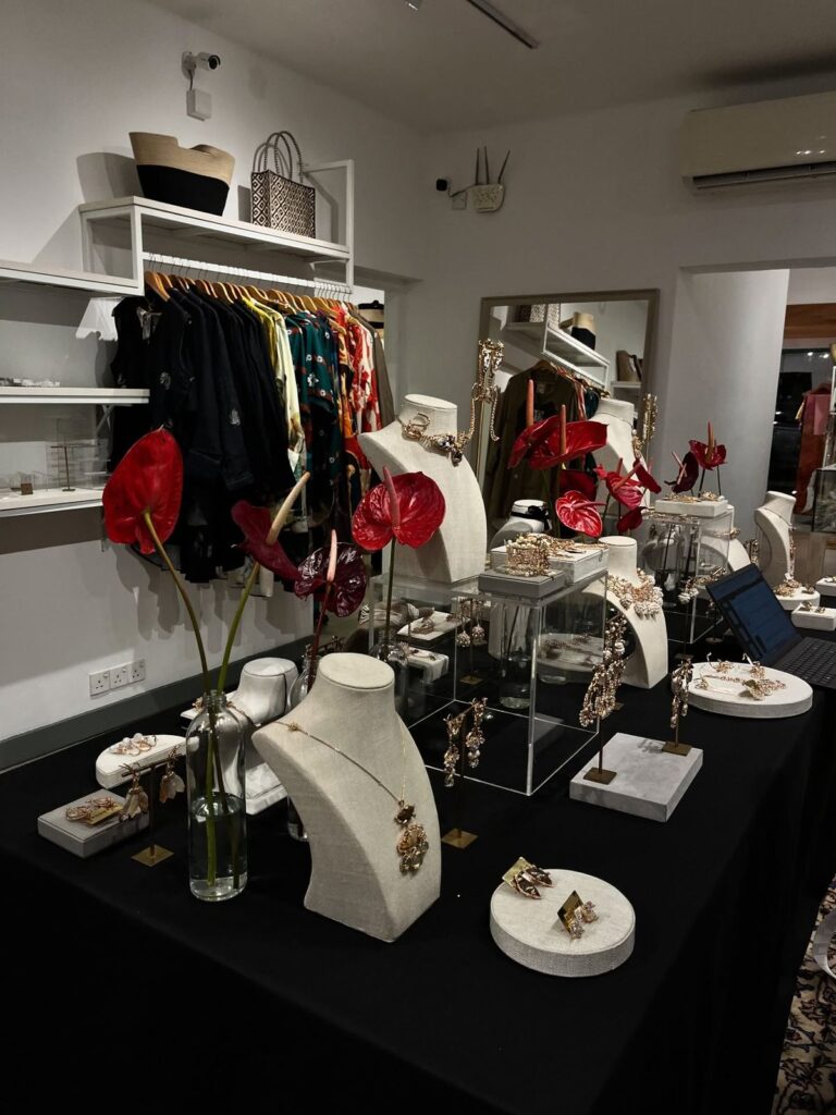 5680bd65cec02f6f1b38a4cfc1231534 Chic boutique display featuring elegant jewelry on stands with stylish clothing in the background, enhancing shopping experience. | Sky Rye Design Chic boutique display featuring elegant jewelry on stands with stylish clothing in the background, enhancing shopping experience.