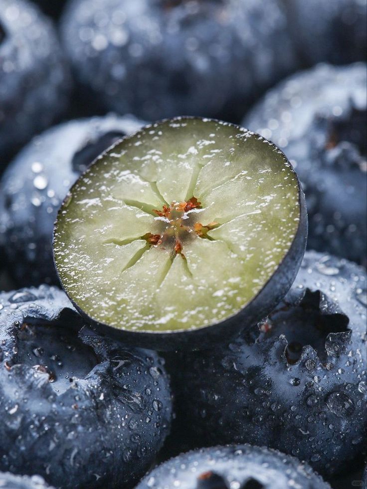 _ 6 Close-up of fresh blueberries covered in water droplets, with one blueberry cut in half showing its green interior. Perfect for healthy eating. | Sky Rye Design Close-up of fresh blueberries covered in water droplets, with one blueberry cut in half showing its green interior. Perfect for healthy eating.