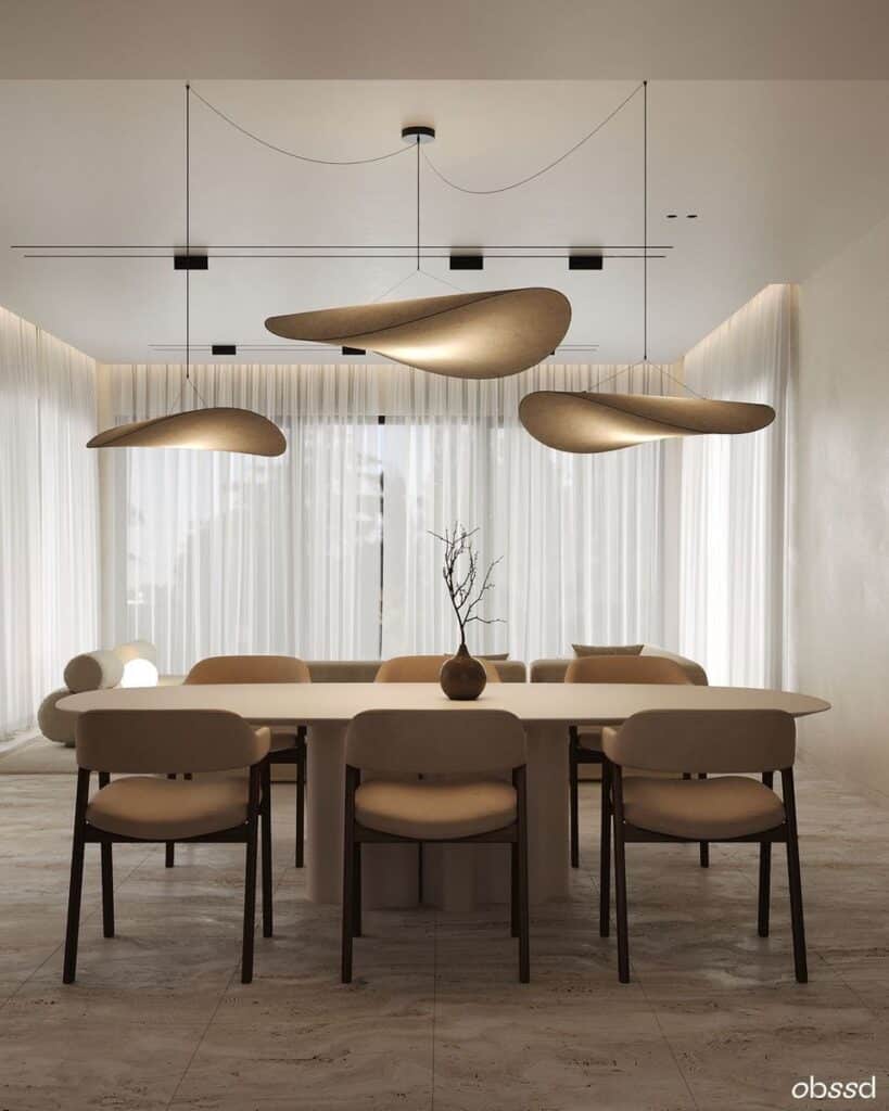 Modern dining room with minimalist decor, featuring a sleek table, beige chairs, and artistic pendant lights against sheer curtains.