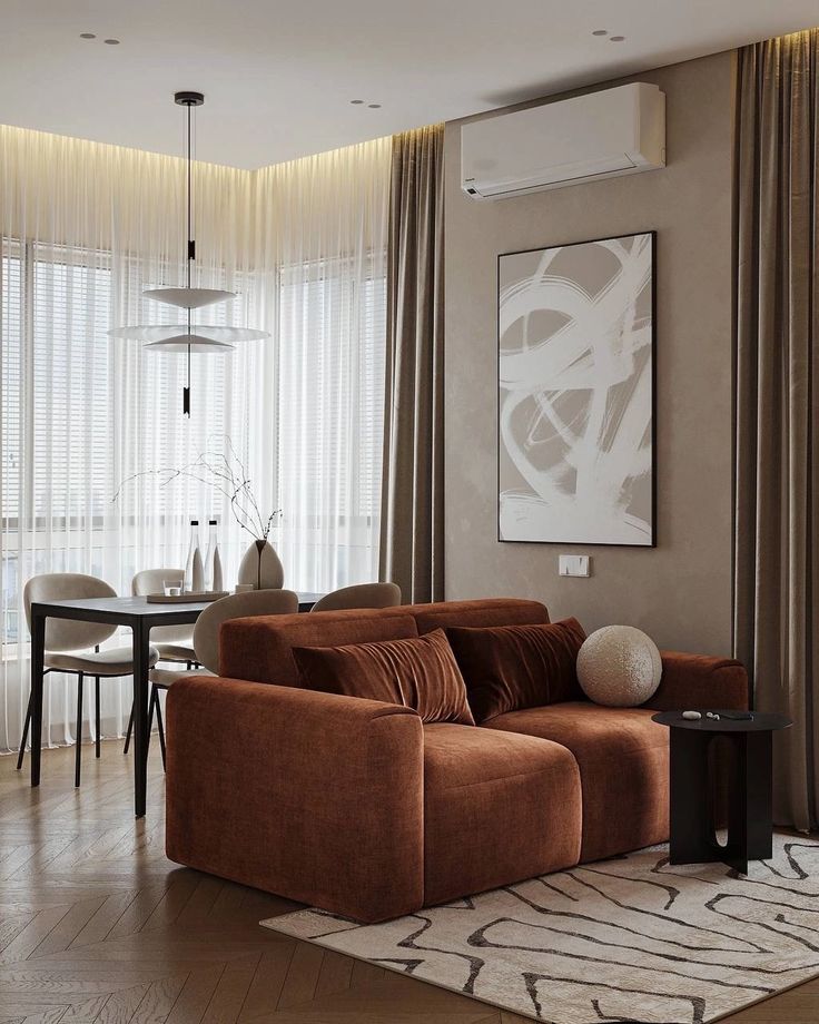 Elegant modern living room with brown sofa, chic dining area, abstract art, and neutral tones, highlighting minimalist interior design.