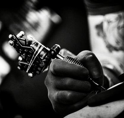 _ 7 Tattoo artist holding a tattoo machine, creating intricate design, black and white close-up shot, emphasizing craftsmanship and detail. | Sky Rye Design Tattoo artist holding a tattoo machine, creating intricate design, black and white close-up shot, emphasizing craftsmanship and detail.