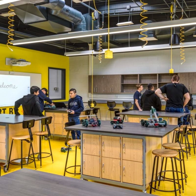 7178f1582bfb024981e54cf23ba2ca16 Students engage with robotics projects in a modern classroom with yellow accents and high-tech equipment. | Sky Rye Design Students engage with robotics projects in a modern classroom with yellow accents and high-tech equipment.