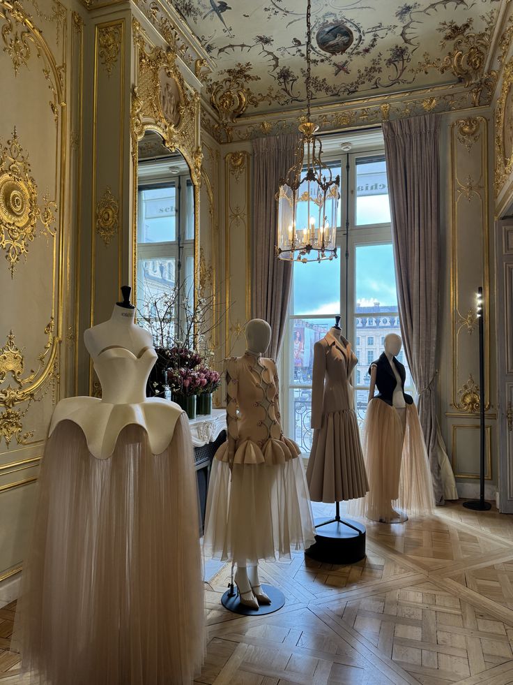 7726b7e5-7285-4e43-a625-eb29e7828881 Luxurious fashion showroom with elegant mannequins wearing designer tulle dresses, set in an opulently decorated room with ornate gold details. | Sky Rye Design Luxurious fashion showroom with elegant mannequins wearing designer tulle dresses, set in an opulently decorated room with ornate gold details.