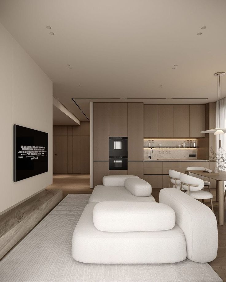 _ 8 Modern living room with minimalist decor featuring a white sofa, wall-mounted TV, and sleek kitchen with wood cabinets and integrated appliances. | Sky Rye Design Modern living room with minimalist decor featuring a white sofa, wall-mounted TV, and sleek kitchen with wood cabinets and integrated appliances.