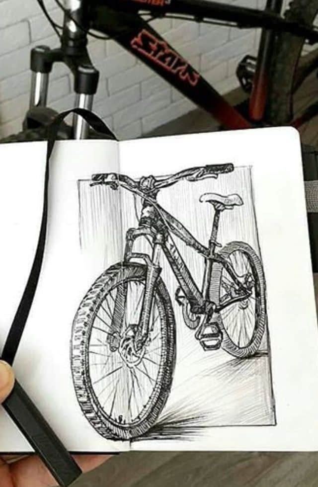 _ 8 Sketch of a bicycle in a notebook against the background of a real bike, showcasing artistic talent and love for cycling. | Sky Rye Design Sketch of a bicycle in a notebook against the background of a real bike, showcasing artistic talent and love for cycling.