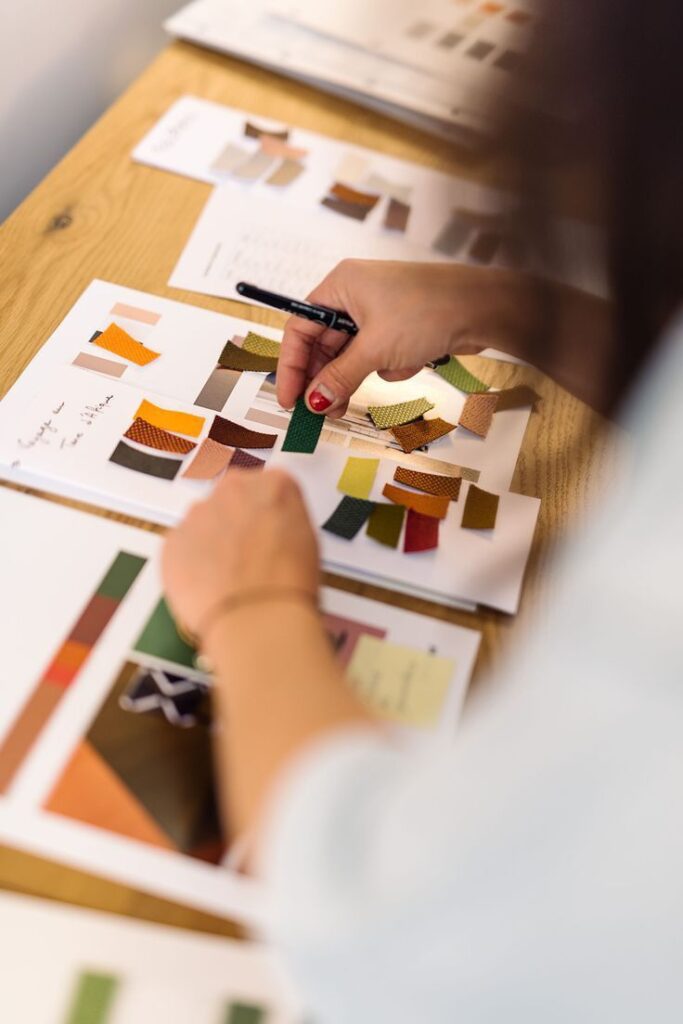 _ 8 Designer organizing colorful fabric swatches on a table for a fashion project. | Sky Rye Design Designer organizing colorful fabric swatches on a table for a fashion project.