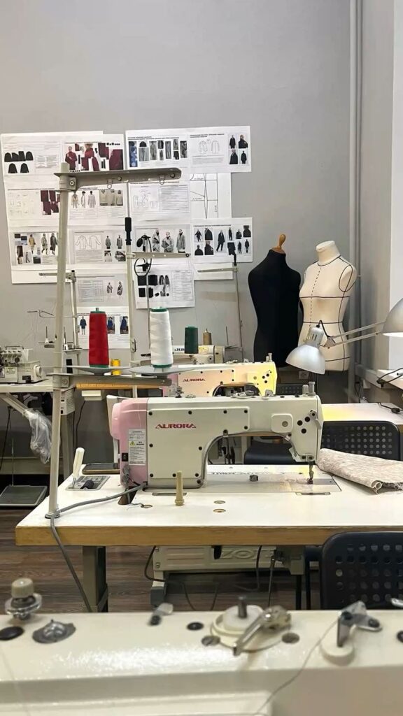 _ 8 Sewing workshop with machines, mannequins, and fashion design sketches on the wall, highlighting a creative garment-making space. | Sky Rye Design Sewing workshop with machines, mannequins, and fashion design sketches on the wall, highlighting a creative garment-making space.