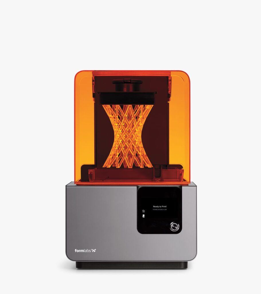 A sleek 3D printer with an illuminated interior, showcasing an intricate geometric design in progress, highlighted by an orange casing.