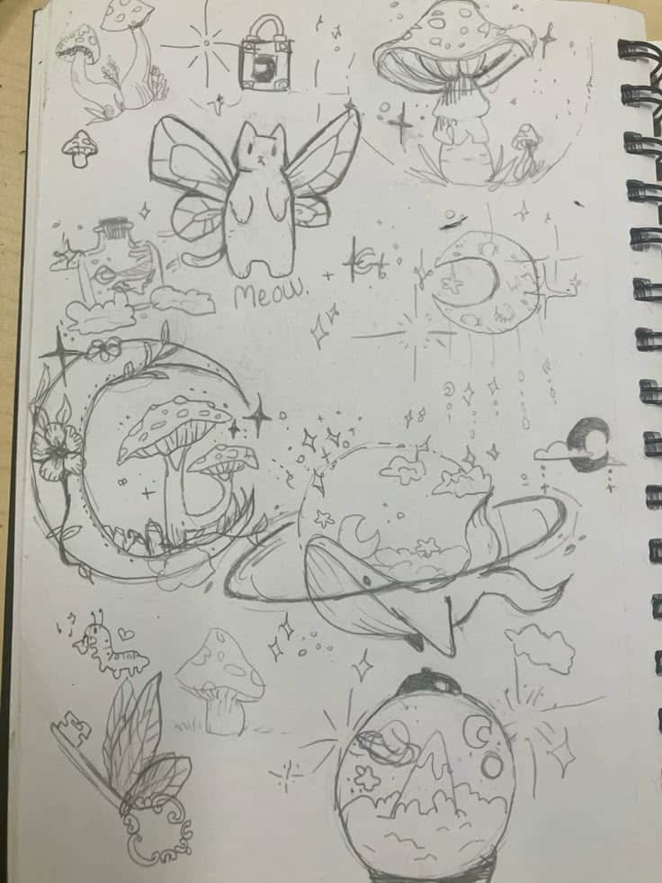 Whimsical pencil doodles featuring flying cat, mushrooms, planets, and stars on sketchbook. Charming and creative fantasy art.