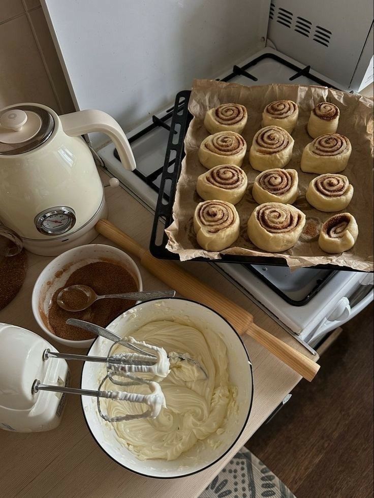 8cd12e0b-db00-4f18-baba-17fd11d5a14d Preparing homemade cinnamon rolls with cream cheese frosting and cinnamon sugar on a cozy kitchen counter setup. | Sky Rye Design Preparing homemade cinnamon rolls with cream cheese frosting and cinnamon sugar on a cozy kitchen counter setup.