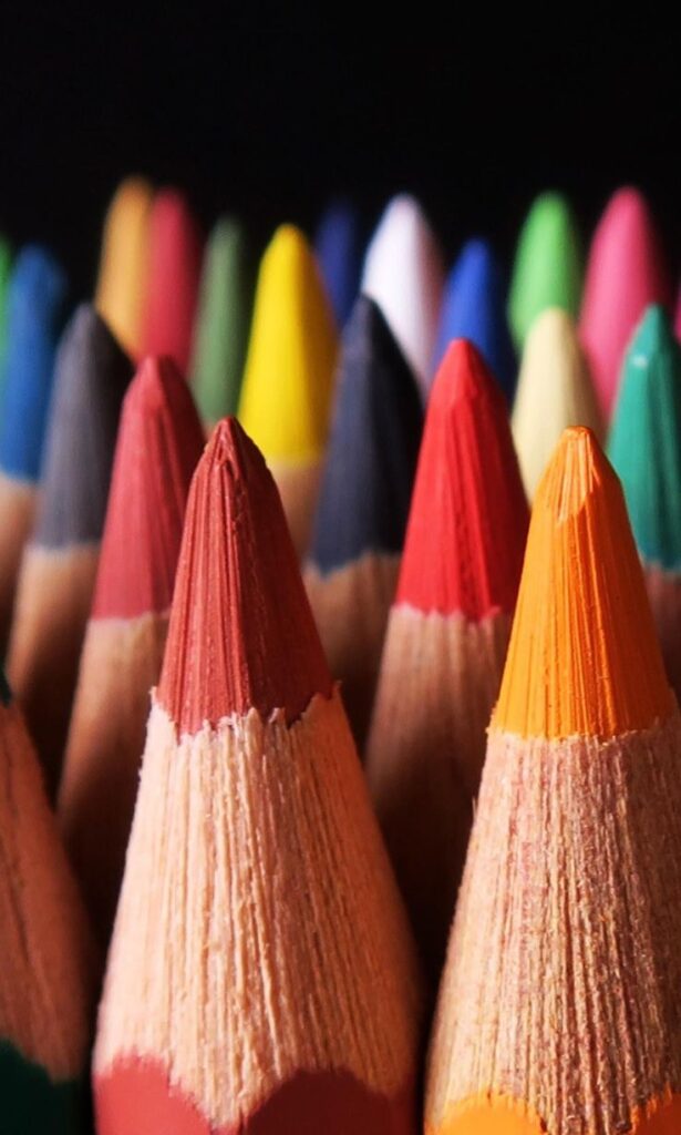 _ 9 Vibrant colored pencils in close-up, showcasing an array of sharp tips against a dark background, ready for artistic creativity. | Sky Rye Design Vibrant colored pencils in close-up, showcasing an array of sharp tips against a dark background, ready for artistic creativity.