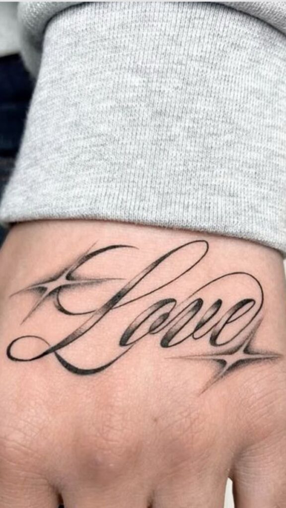 Stylish Love tattoo on hand, featuring elegant script with star accents, showcasing a unique design on skin.
