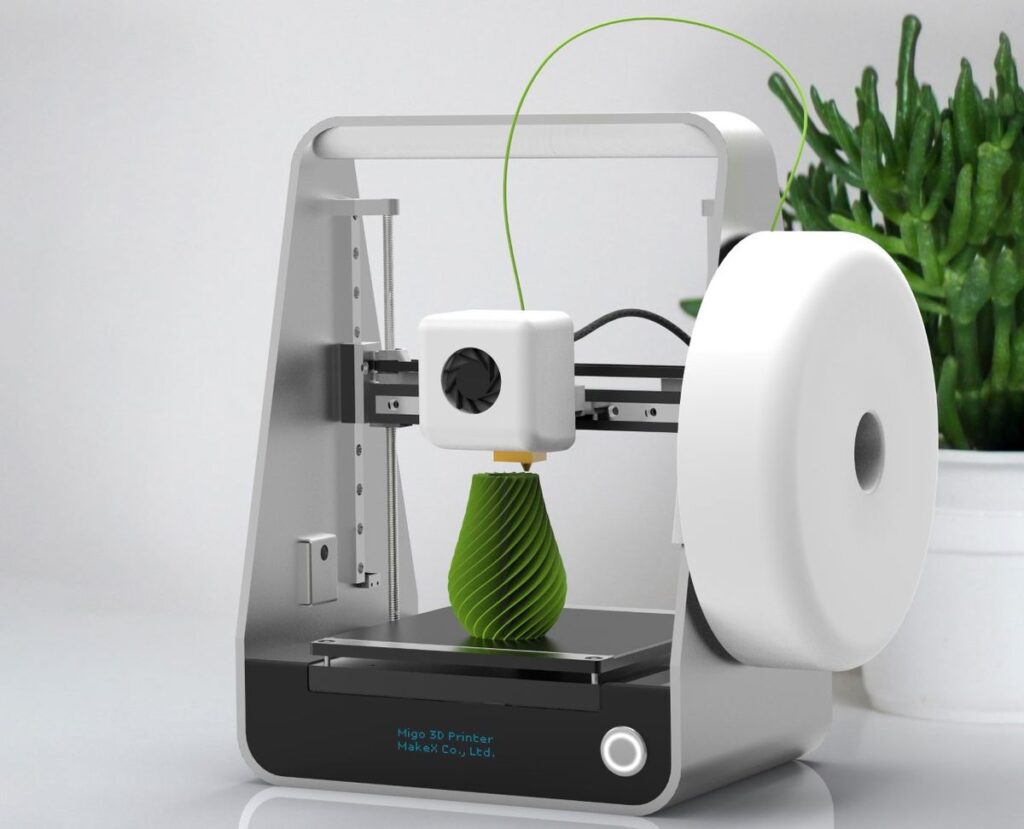 9e71d074a7a8515a540706d38dfdaf2a Compact 3D printer creating a green object with a spool of filament, placed on a sleek desk with a plant in the background. | Sky Rye Design Compact 3D printer creating a green object with a spool of filament, placed on a sleek desk with a plant in the background.