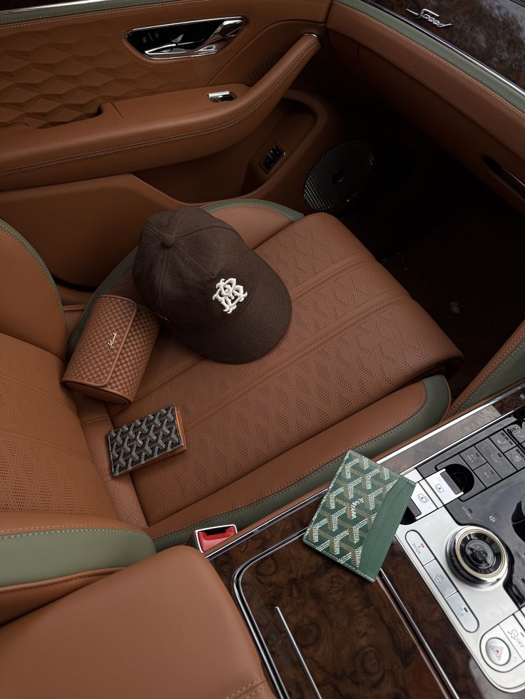 Luxury car interior with brown leather seats, stylish hat, and designer accessories for a sophisticated travel experience.