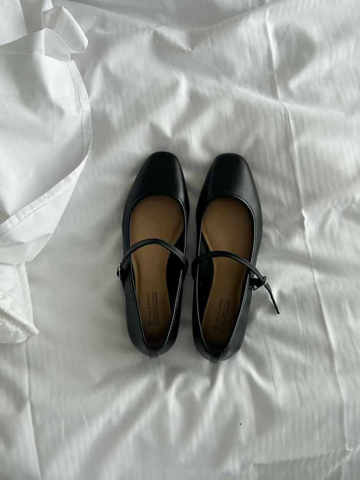 Ballerina Black Mary Jane flats with square toes, placed on a white bed sheet, showcasing a stylish and classic footwear design. | Sky Rye Design Black Mary Jane flats with square toes, placed on a white bed sheet, showcasing a stylish and classic footwear design.