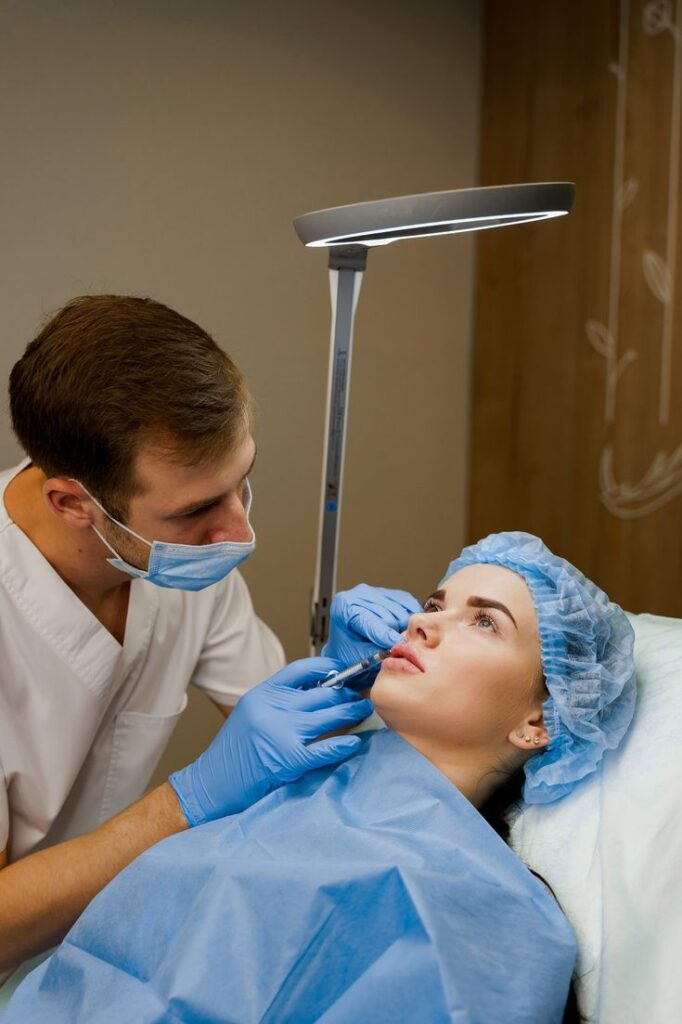 Beverly Hills Aesthetic Surgeries Cosmetic procedure in progress: Professional administering facial injection to woman in medical setting, enhancing facial aesthetics. | Sky Rye Design Cosmetic procedure in progress: Professional administering facial injection to woman in medical setting, enhancing facial aesthetics.