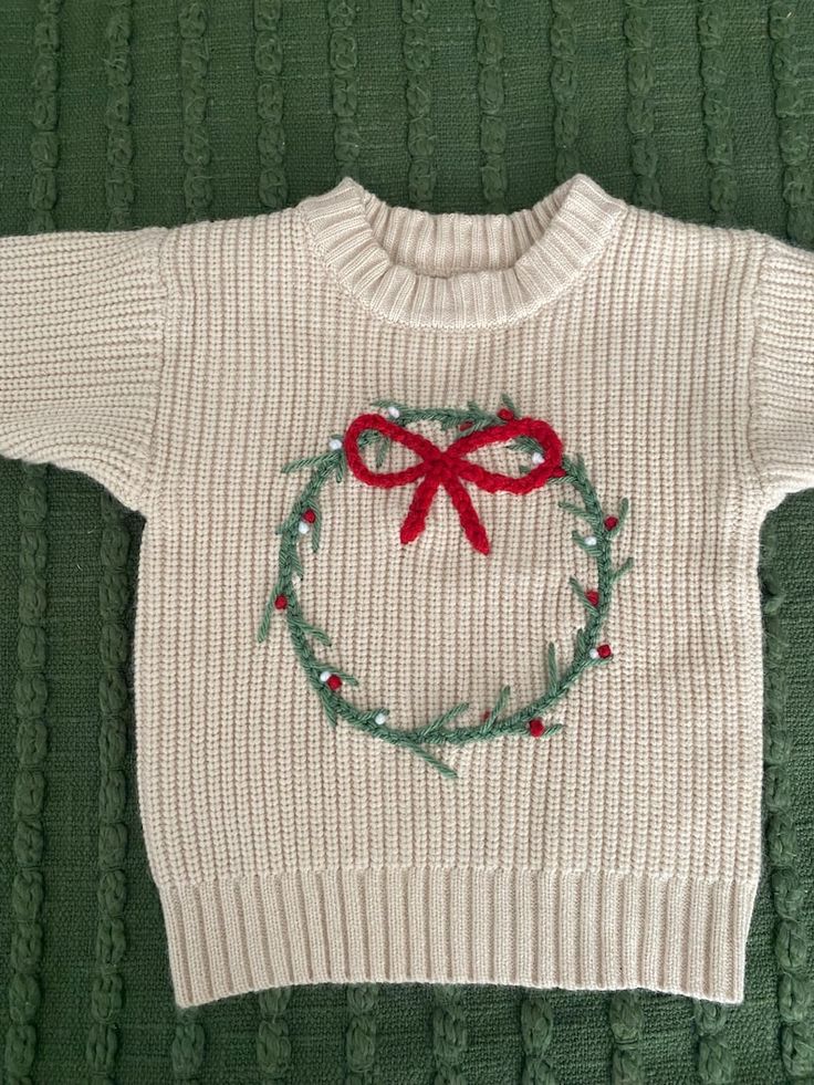 Childrens Christmas Jumper - Etsy Knitted cream sweater with red and green wreath design on green textured background, perfect for festive holiday outfits. | Sky Rye Design Knitted cream sweater with red and green wreath design on green textured background, perfect for festive holiday outfits.