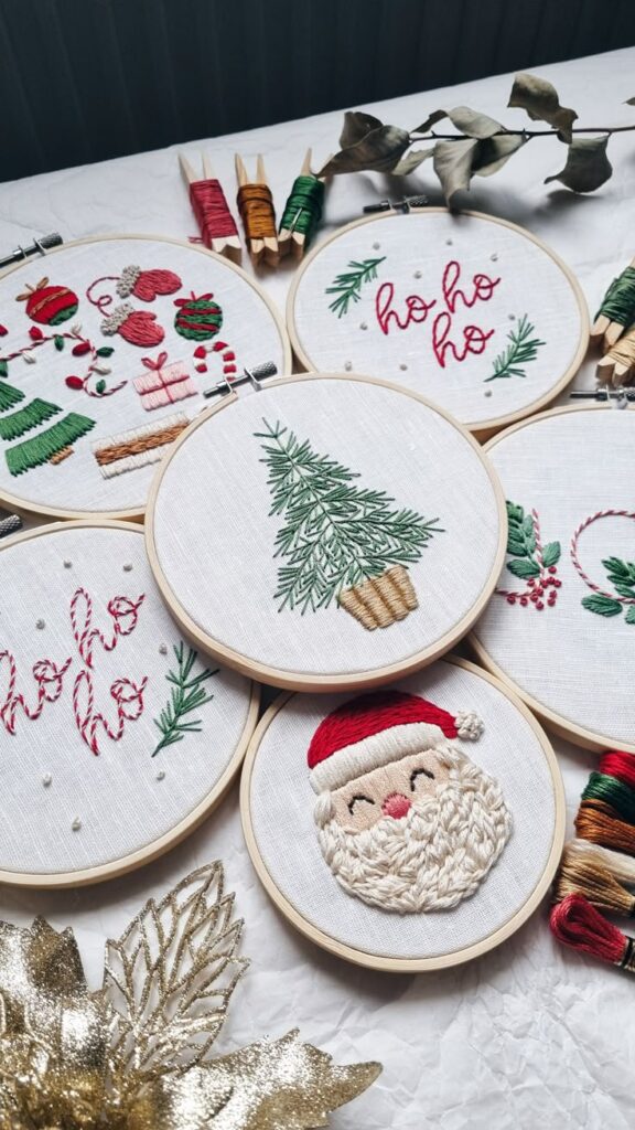 Processed with VSCO with hb1 preset Handmade Christmas embroidery art featuring Santa, a tree, and ho ho ho in hoops, with colorful threads on a white background. | Sky Rye Design Handmade Christmas embroidery art featuring Santa, a tree, and ho ho ho in hoops, with colorful threads on a white background.