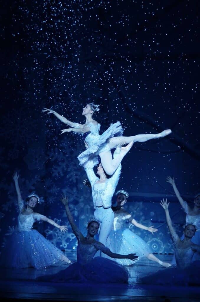 Cody Beaton and Marty Davis in Richmond Ballet Nutcracker Ballet dancers perform gracefully on stage during a snow-themed performance, creating a magical winter atmosphere with elegant poses. | Sky Rye Design Ballet dancers perform gracefully on stage during a snow-themed performance, creating a magical winter atmosphere with elegant poses. Winter Theatre Events