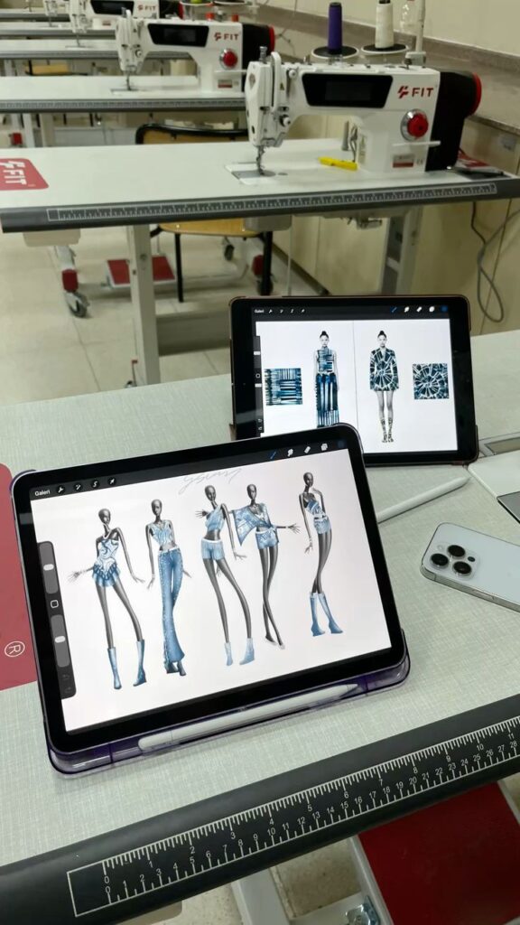 Collection Fashion design sketches on tablets in a sewing workshop with machines. | Sky Rye Design Fashion design sketches on tablets in a sewing workshop with machines.