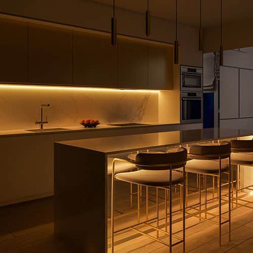 Modern kitchen with warm ambient lighting, marble countertops, sleek cabinets, and stylish bar stools. Cozy and elegant design.