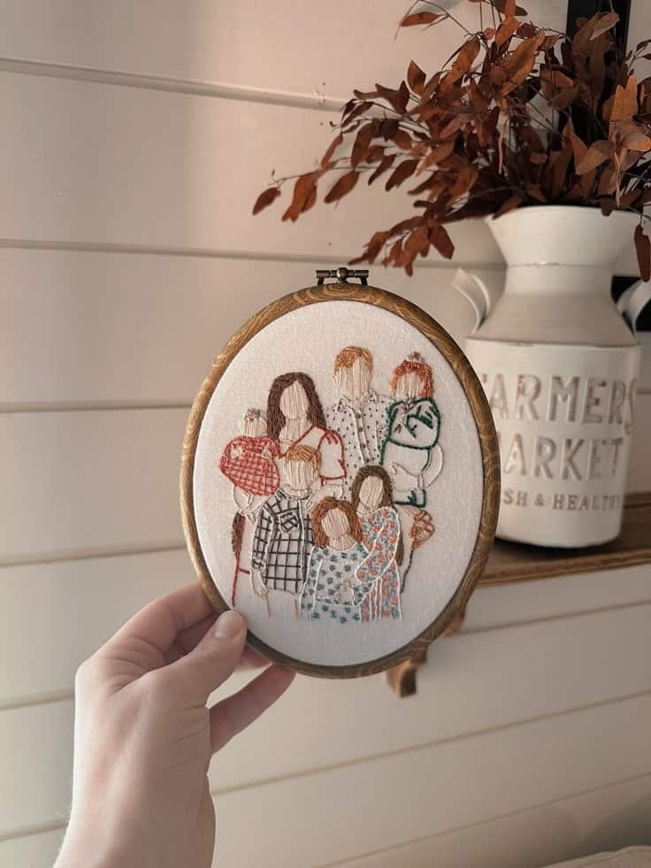 Custom Embroidery Portrait Embroidered family portrait in a hoop held by hand, with rustic decor in the background. Warm, cozy handmade wall art. | Sky Rye Design Embroidered family portrait in a hoop held by hand, with rustic decor in the background. Warm, cozy handmade wall art.